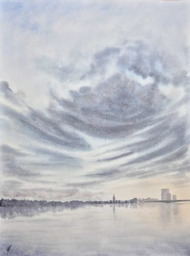 Dramatischer Himmel mit Wolken über einem ruhigen Gewässer und silhouettierten Gebäuden.